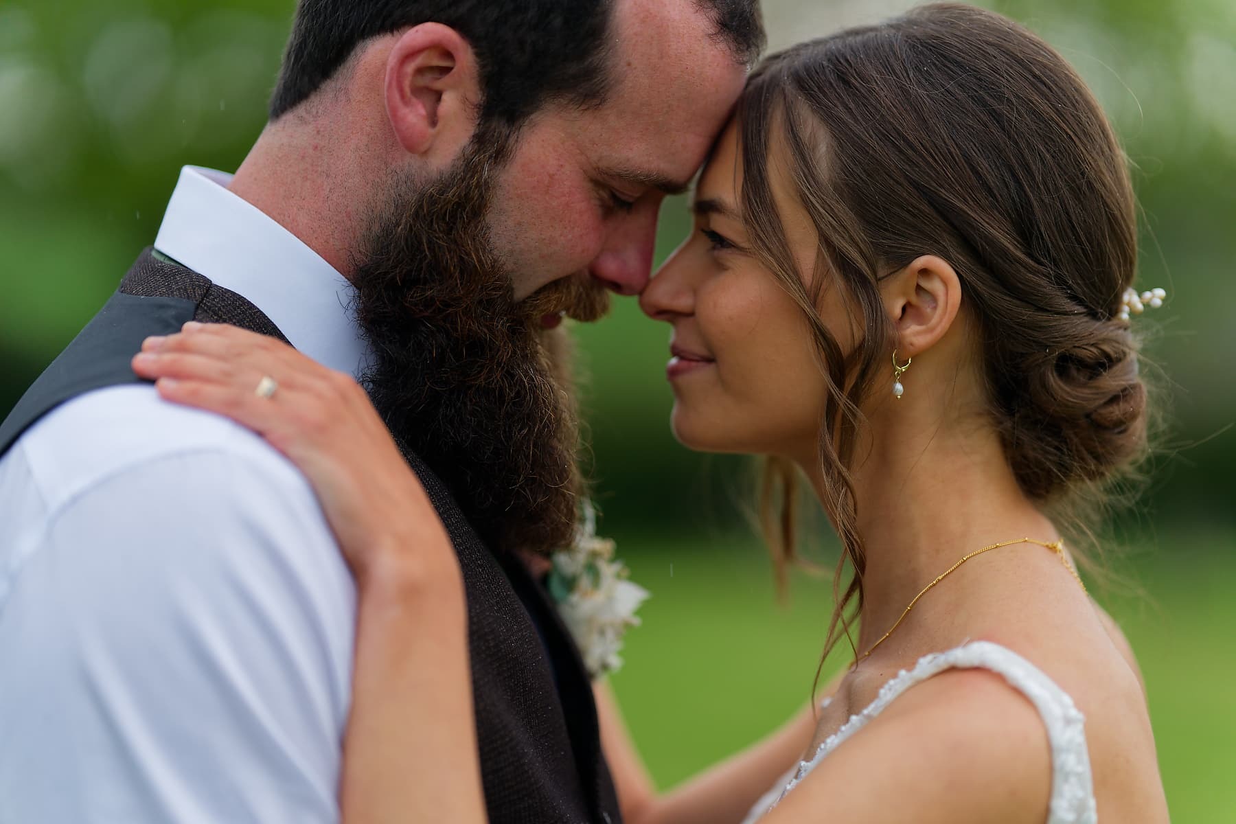 Newlyweds sharing a quiet moment outdoors during their rainy Cornwall wedding