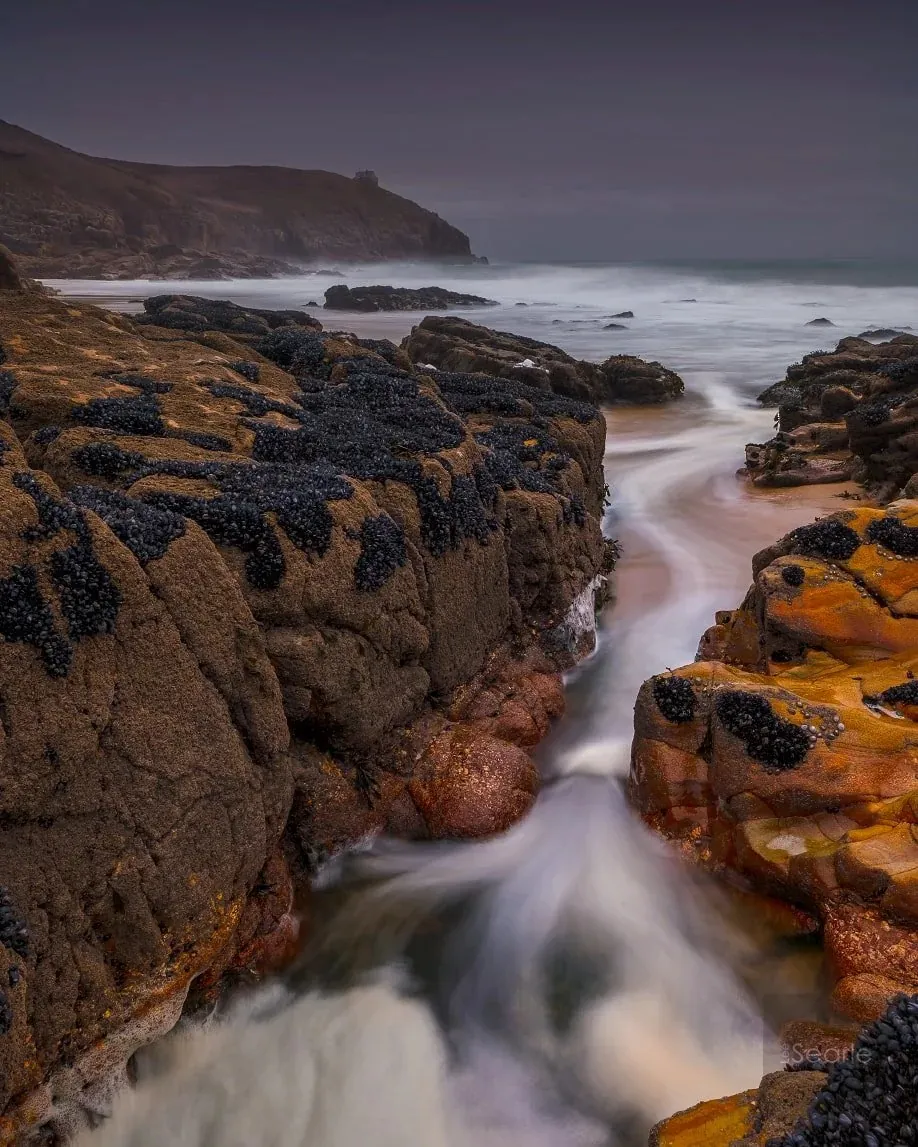 Long exposure of a stream tumbling over rocks into the sea on the Cornish coast