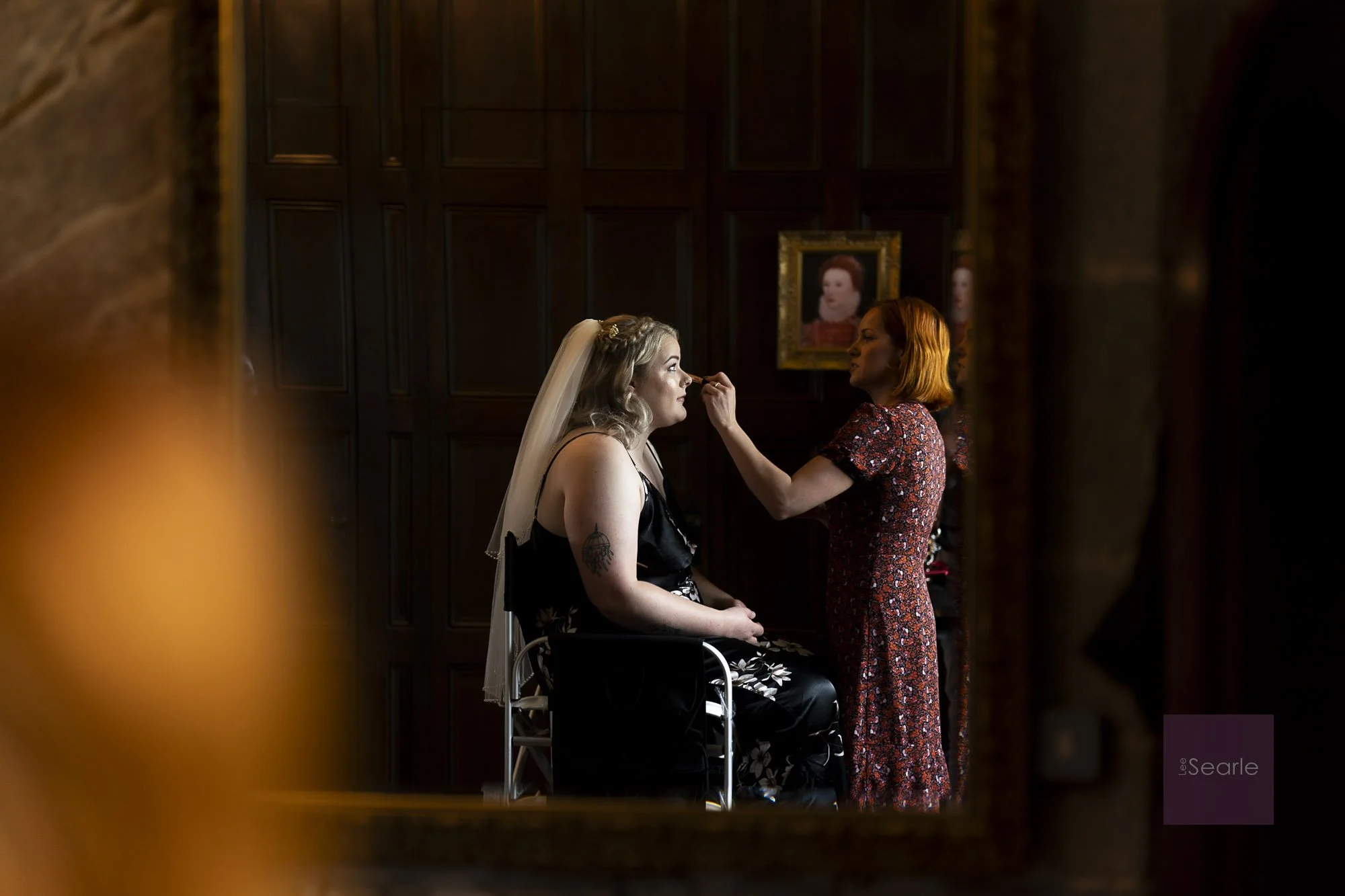 Finishing touches in the mirror during bridal prep at Pengersick Castle