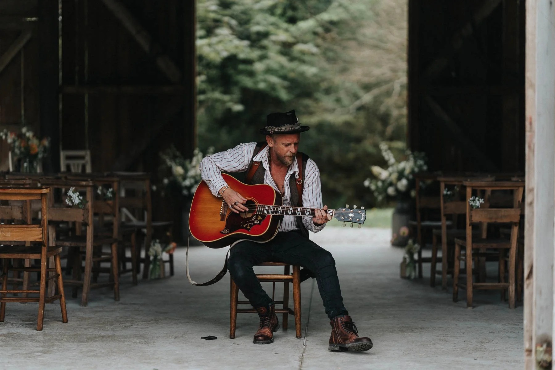 Lee Searle before a Cornwall wedding Lee Searle playing guitar inside a rustic barn before a Cornwall wedding