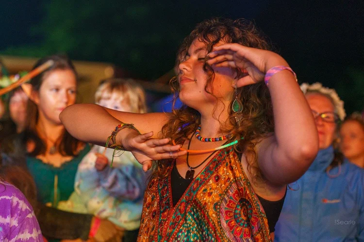 Dancer in orange lamplight at a Cornish festival at night